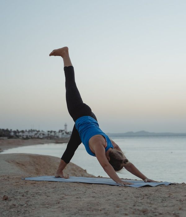 Woman in a calming yoga pose against a dark, serene background.